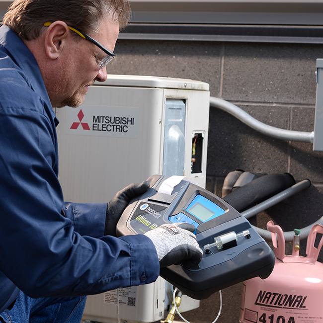 Technician servicing an HVAC system using R-410A refrigerant